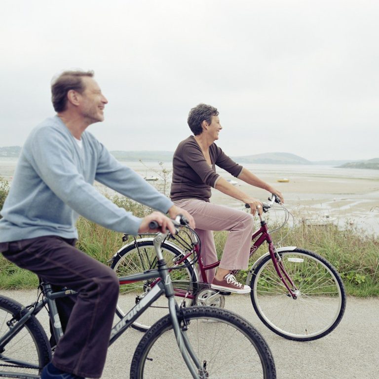 Fahrrad Ein Mann und eine Frau fahren auf Fahrrädern in einer malerischen Küstenlandschaft.