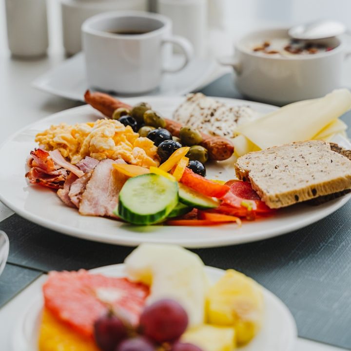 Gesundes Frühstück Ein reichhaltiges Frühstück mit Wurst, Käse, Gemüse, Obst und Kaffee.