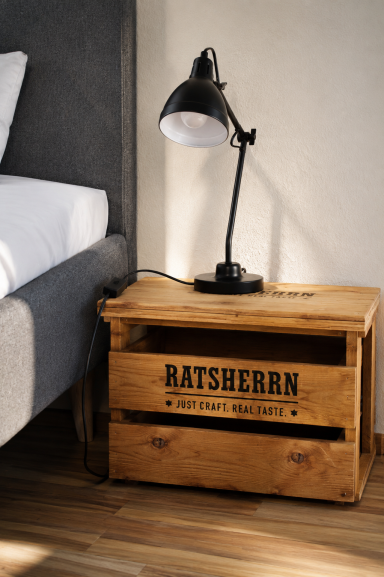 Liebe zum Detail Holzkasten als Nachttisch mit Lampe daneben, in einem modernen Schlafzimmer.